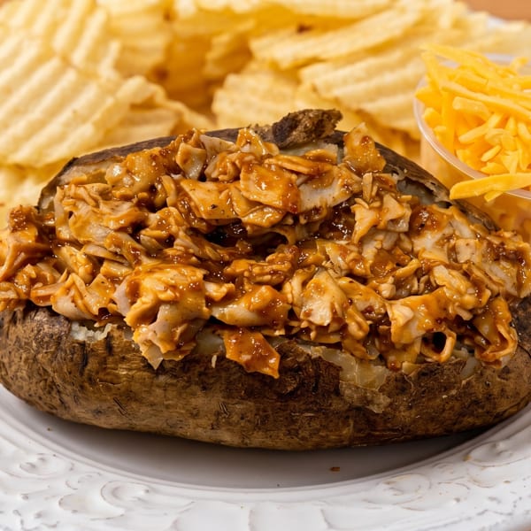 Baked potato topped with BBQ chicken, served with ruffled potato chips and shredded cheddar cheese.